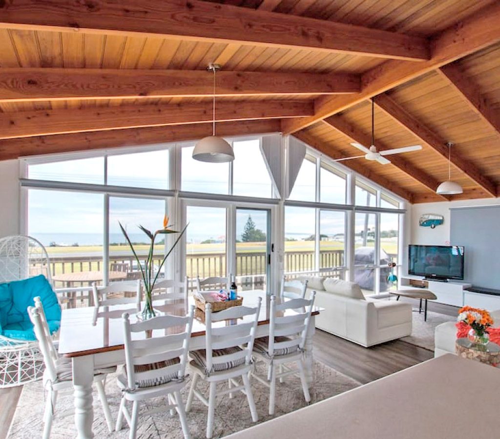 Open-concept dining and living area with elegant white decor and sweeping ocean views at Killy Views